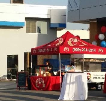 Bombdiggity catering tent and hot dog cart at an event